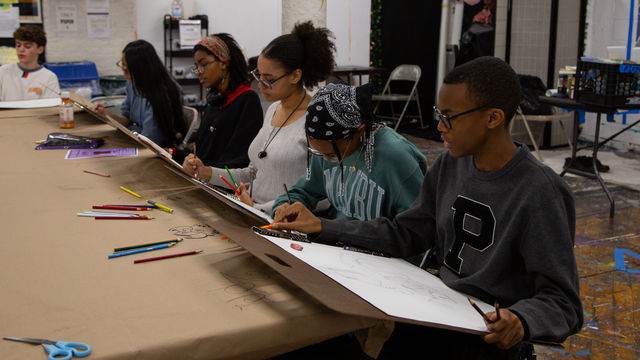 Row of artists drawing 