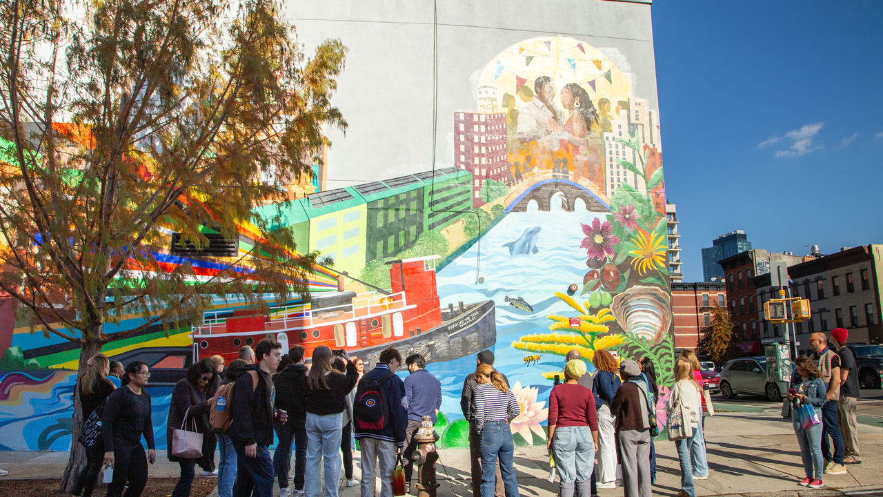 Group of people looking at mural on the wall