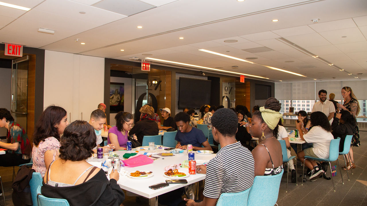 Group of students and teachers talking at tables