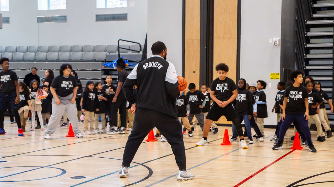 Basketball couch showing students a drill 
