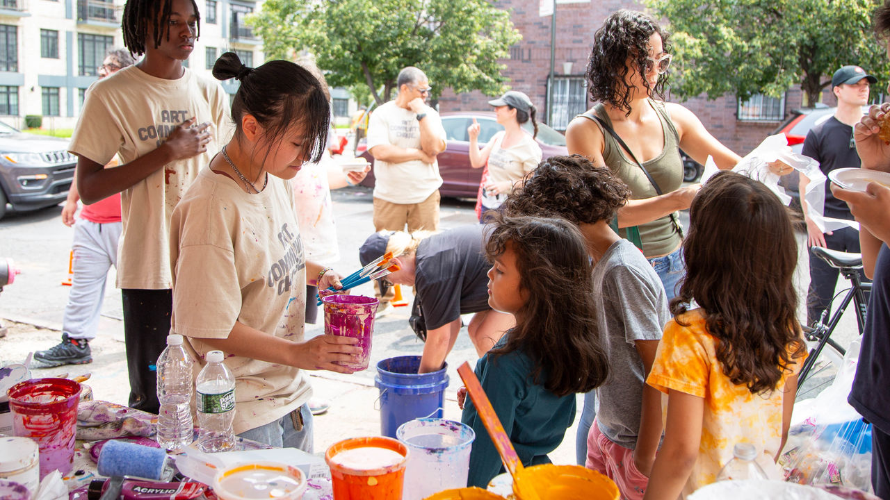 Student helping kids pick out paint.