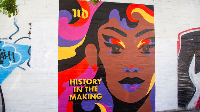 Mural that has colorful swirls that has a portrait of a woman and says "history in the making"