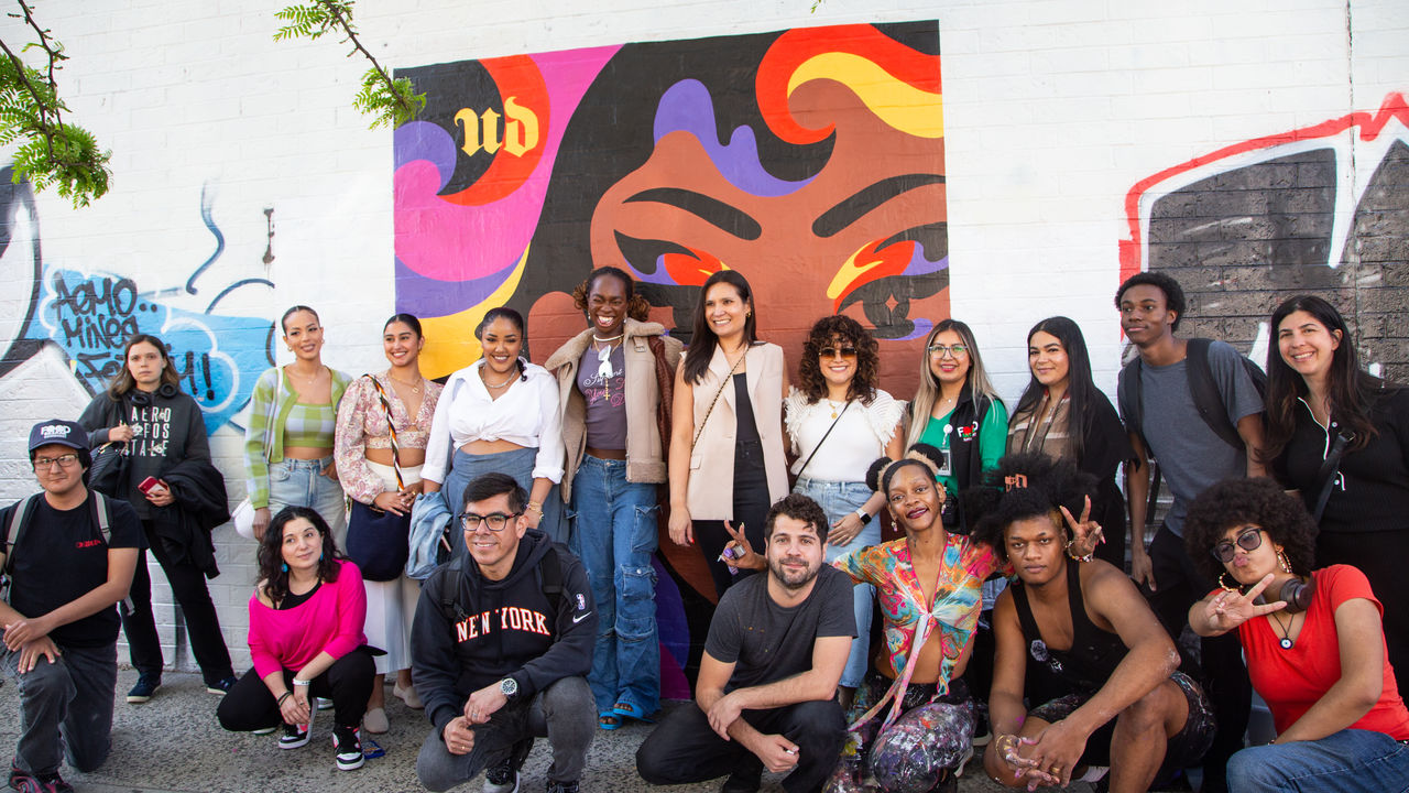 Group of people posing in front of a completed mural 