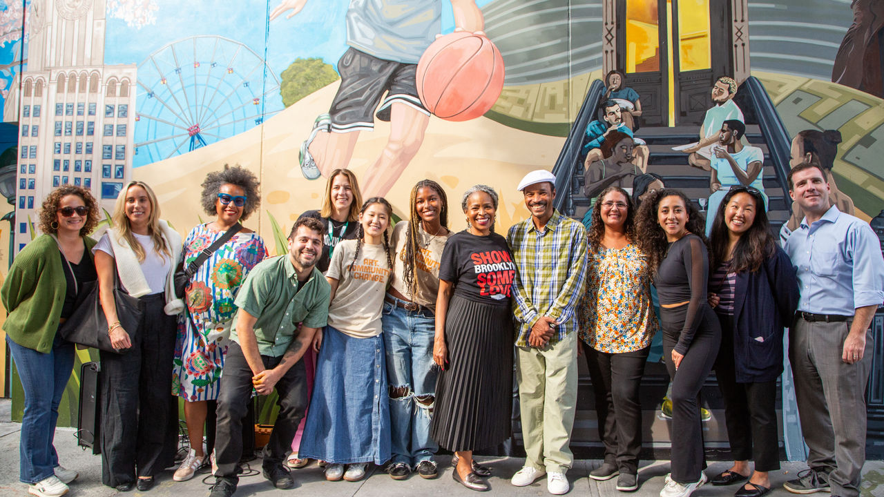 Group photo in front of a mural 