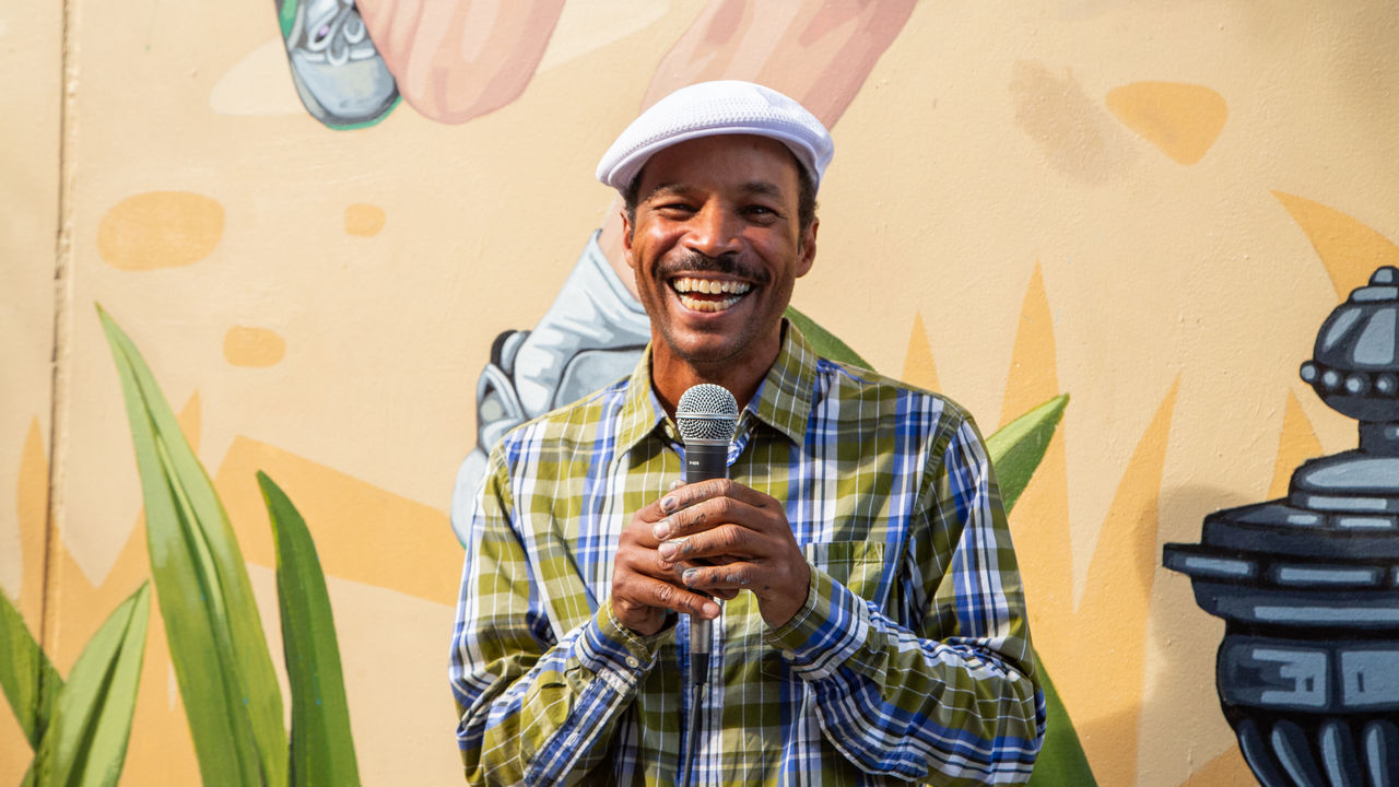 Man smiling holding microphone