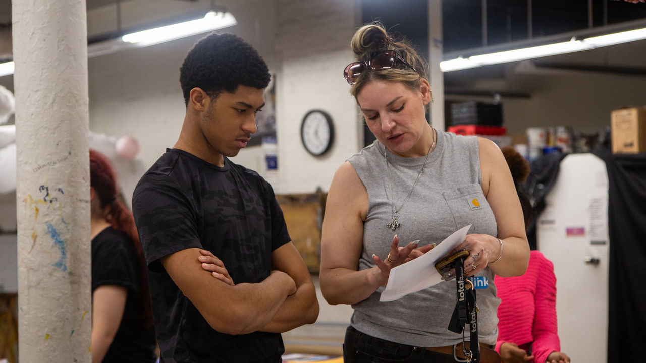 Teacher talking to student about work. 