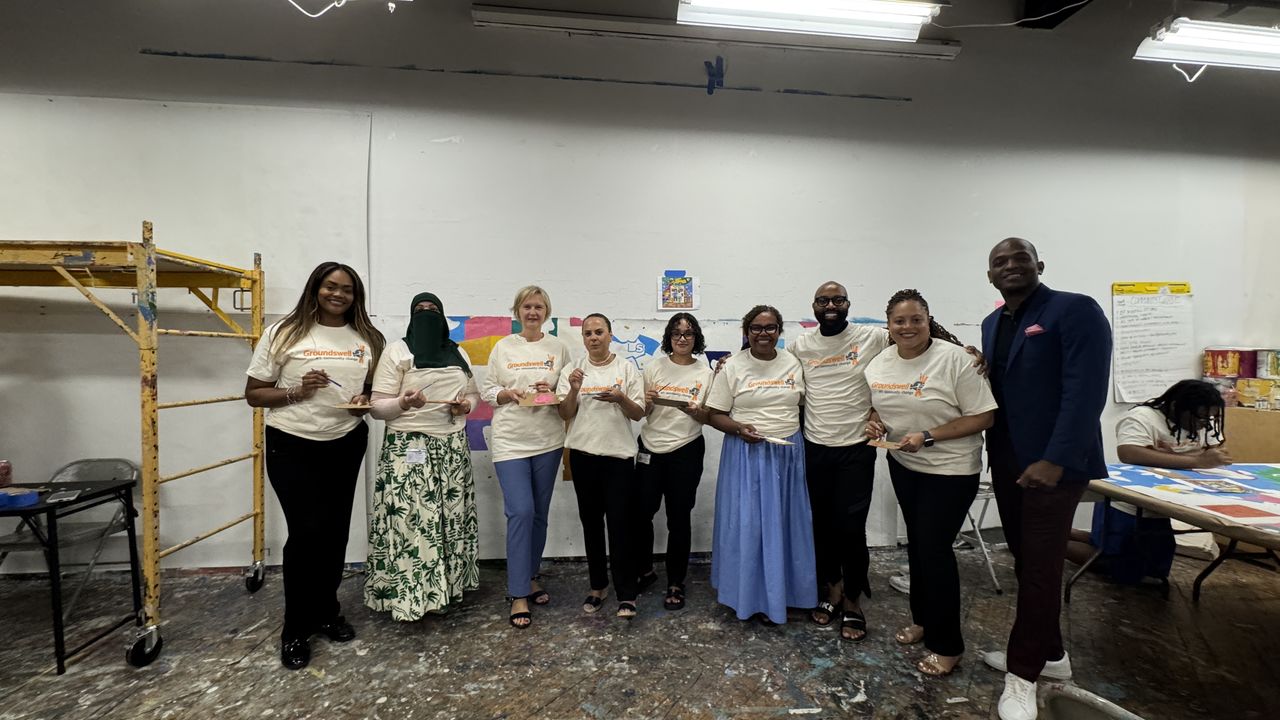 Group photo of people holding paint brushes