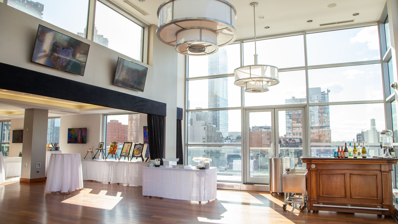 Wide shot of space showing outdoor rooftop view and art auction set up 