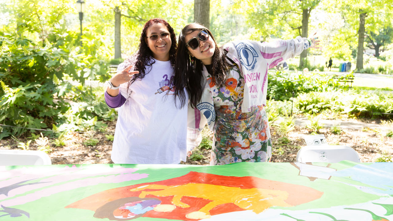 Executive Director and Teaching Artist posing with artwork 