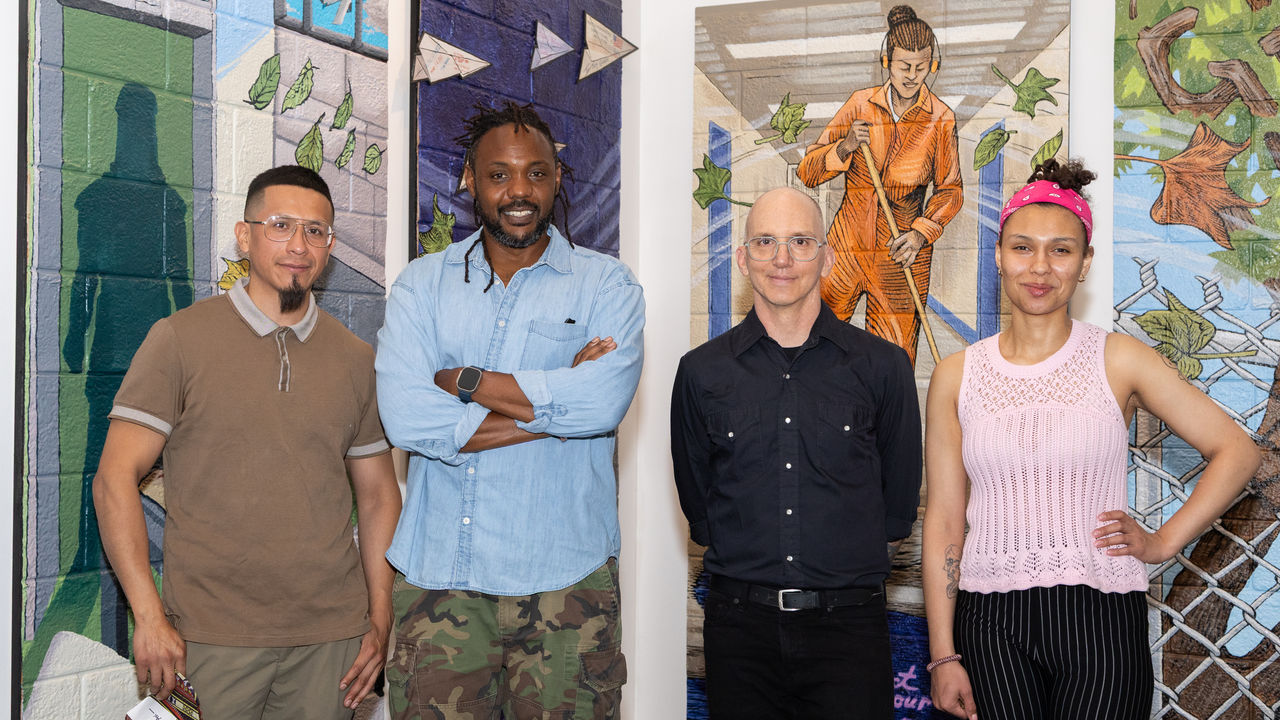 Group of artists posing in front of their artwork 